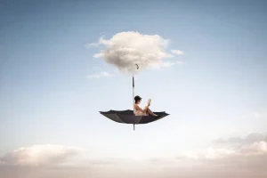 Significado de los sueños y mundo onírico representado por una persona leyendo sobre una nube en el cielo, símbolo de interpretación de sueños y vida interior
